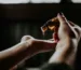 person holding amber glass bottle